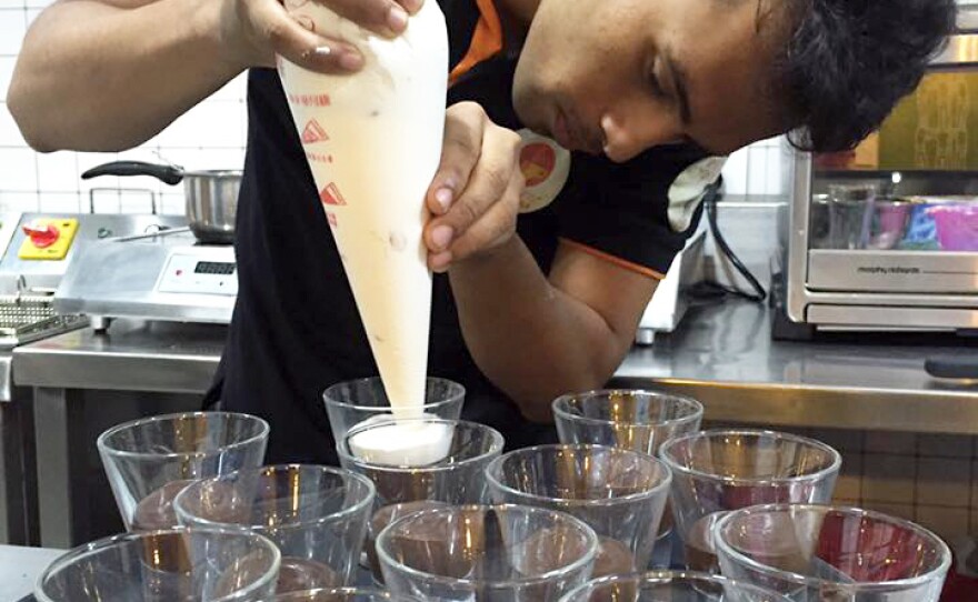 Staff at the cafe make pudding cups.
