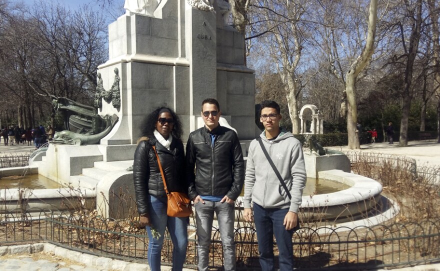 Jaqueline Madrazo Luna (left), Rafael León (center) and Ernesto Oliva Torres, pose in front of a Cuba monument in Madrid's Retiro Park. The Cuban government granted them two-week travel permits to visit Spain. They are meeting with the Cuban Observatory of Human Rights, which includes exiled Cuban activists.