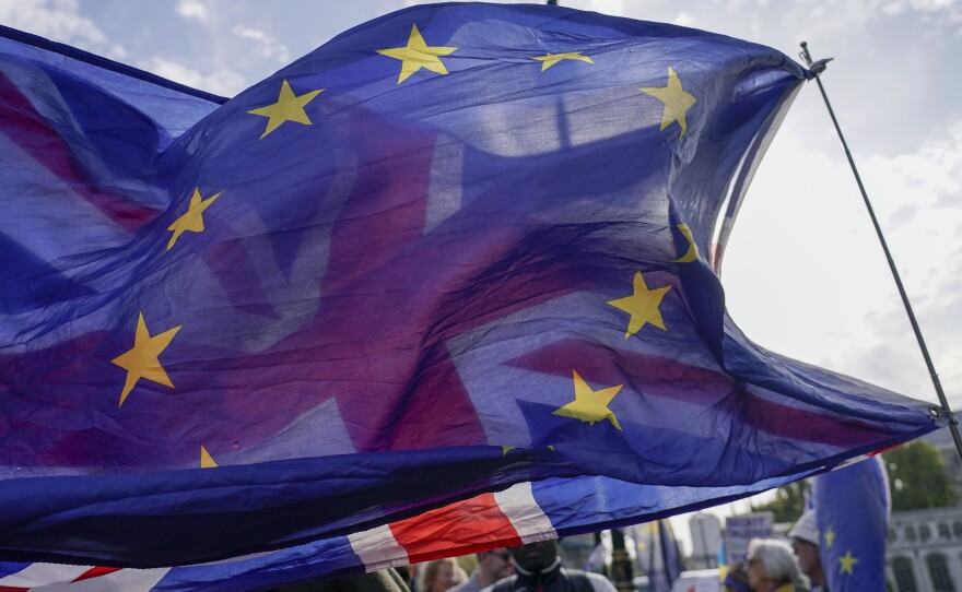 A Union flag waves behind a European Union flag outside the Houses of Parliament in London on Oct. 19. The British government denied a report on Nov. 20 that it is seeking a "Swiss-style" relationship with the European Union that would remove many of the economic barriers erected by Brexit — even as it tries to repair ties with the bloc after years of acrimony.