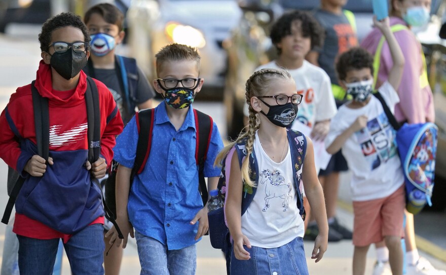Students arrive for the first day of school at Sessums Elementary School in Hillsborough County, Fla., on Aug. 10. After thousands of students were put in isolation or quarantine, the district is revisiting its safety protocols, including its current mask-optional policy.