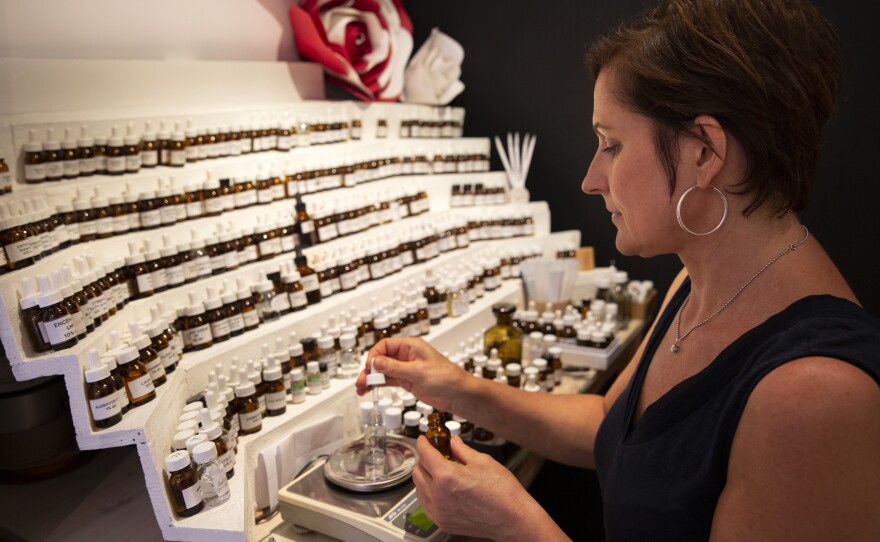 Jessica Buchanan, owner of the 1,000 Flowers shop in Grasse, creates perfumes at her perfumer's organ displaying hundreds of vials of scents.