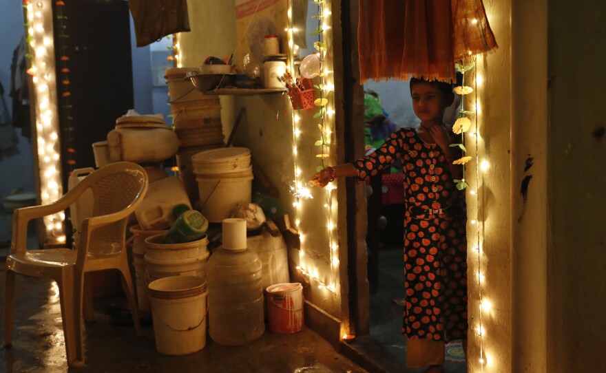 A girl plays with firecrackers during Diwali on Sunday in New Delhi. Hindus light lamps, wear new clothes, exchange sweets and gifts and pray to the goddess Lakshmi during Diwali, the festival of lights.