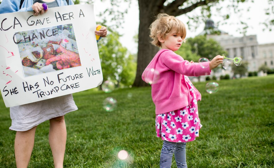 Charlie Wood of Charlottesville, Va., plays with bubbles during a May 4, 2017, rally near the Capitol to oppose proposed changes to the Affordable Care Act. Charlie was born a few months prematurely, and her mother, Rebecca (left), fears changes to the health law will negatively affect her care.