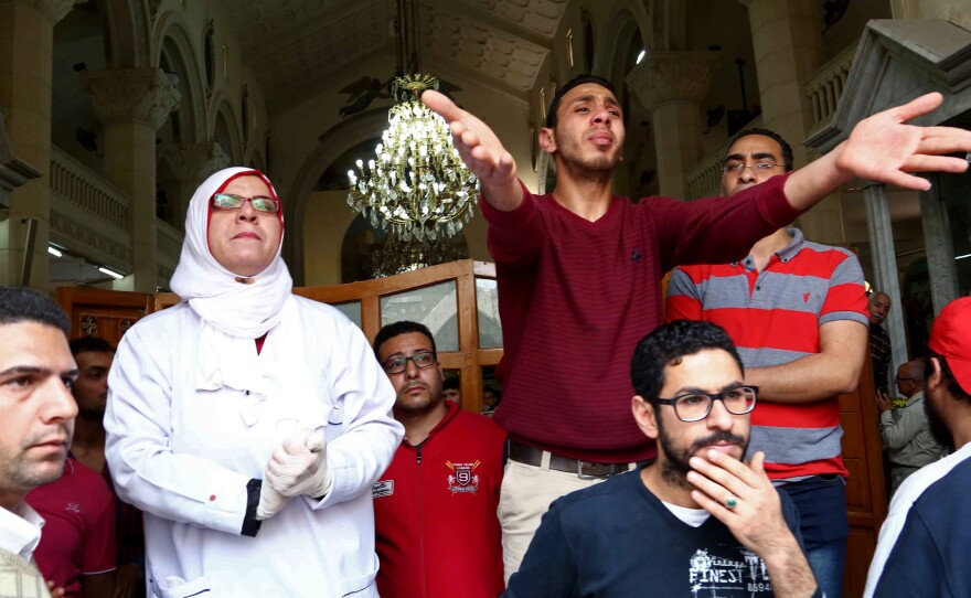 People react at the site of a bomb attack which struck worshippers gathering to celebrate Palm Sunday at the Mar Gerges church in Tanta, Egypt.