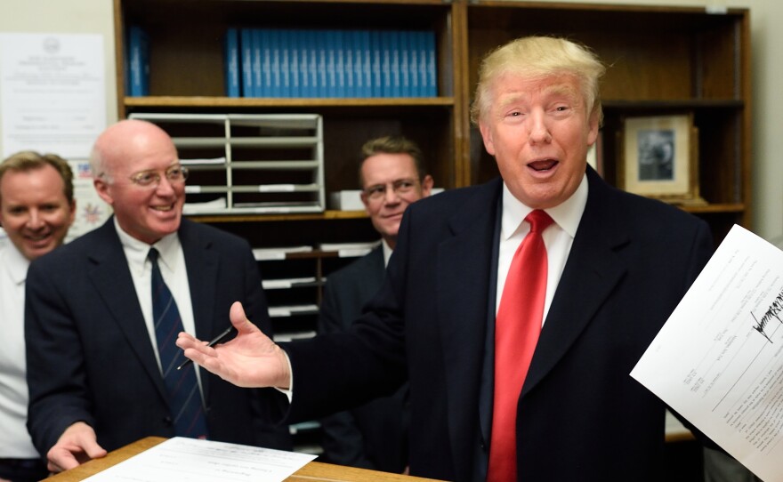 Donald Trump files to get on for the New Hampshire primary state ballot as longtime state Secretary of State Bill Gardner looks on.