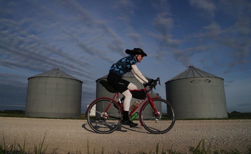 A rider passes by a set of silos along the optional gravel loop Tuesday, July 26, on his way from Pocahontas to Havelock, Iowa, on Day 3 of RAGBRAI.