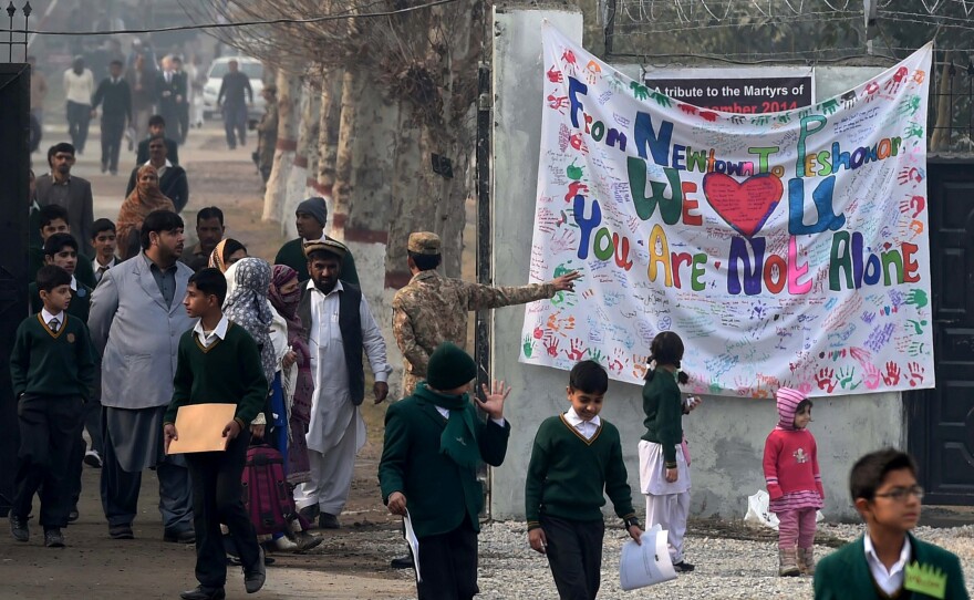 Pakistani parents leave the Army Public School with their children after it was reopened on Jan. 12. Most of the surviving students and teachers returned to the school.