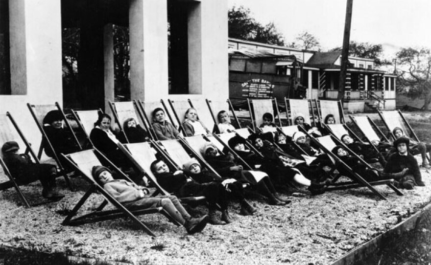 Group of children sitting outside on chairs, taking the air.