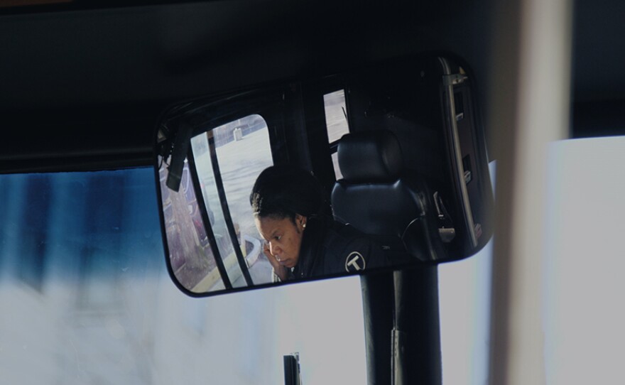 Kafi at work, driving a city bus. 