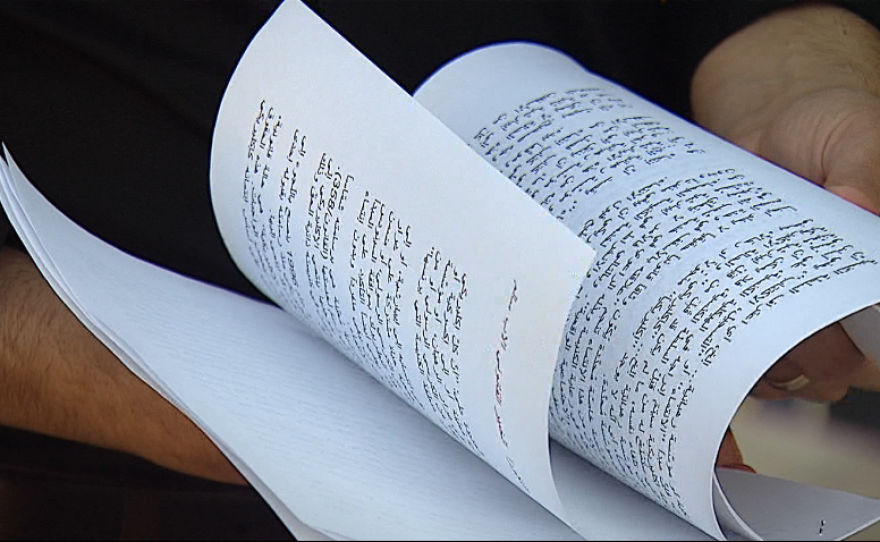 Mark Arabo, president of the Neighborhood Market Association and a spokesman for the Chaldean-American community, flips through a printed copy of a decree calling for Chaldean Catholic priests in the United States to return to Iraq, Oct. 22, 2014.
