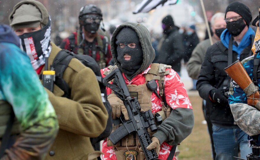 Armed demonstrators protest outside of the Michigan state capital building on Sunday in Lansing, Michigan.