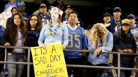 A fan holds up a sign commenting on the possible move by the San Diego Chargers during an NFL football game against the Miami Dolphins in San Diego, Dec. 20, 2015. 