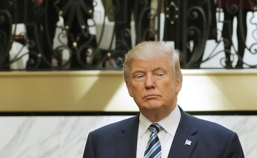 Hotel employees watch then-Republican presidential nominee Donald Trump following a ribbon cutting ceremony at the new Trump International Hotel October 26, 2016 in Washington, D.C.