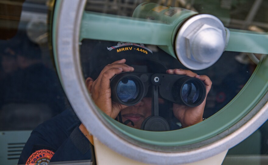 A members of the Philippine Coast Guard takes part in a simulation during a maritime exercise with Japan and U.S. Coast Guard on June 6, off the coast of Bataan province, western Philippines. The drills that took place in waters facing the South China Sea included maneuverings, maritime law enforcement and search and rescue at sea.