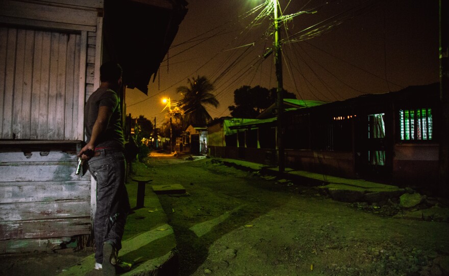 A gang member protects a block of their turf in San Pedro Sula. The decades-long fighting has made enemies of people who might live just a block away from each other, says Ayuso.