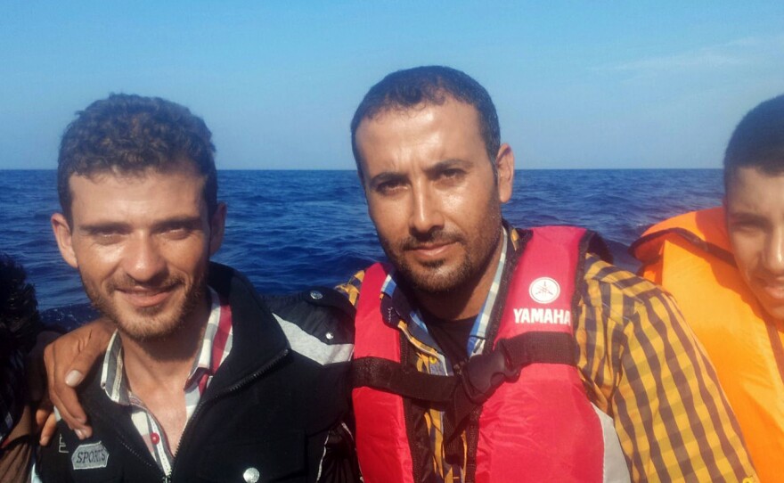 Monzer Omar, center, and his friend, Hatem Alhees, left, traveled by raft from Izmir, Turkey, to Lesbos, Greece.