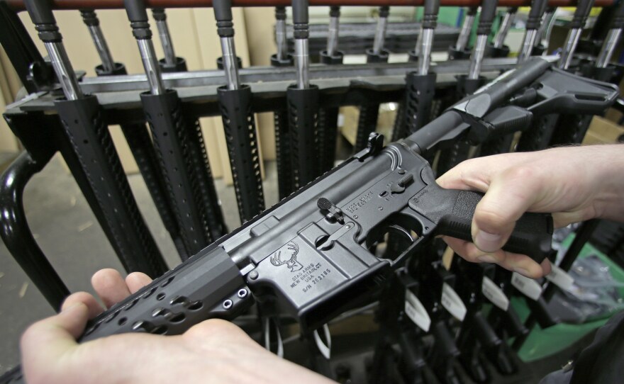Veetek Witkowski holds a newly assembled AR-15 rifle at the Stag Arms company in New Britain, Conn., in April.