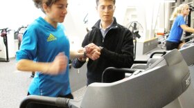 Ben Rapoport takes Erin Wyner's pulse as she runs on a treadmill to determine how many carbohydrates she should eat to run a successful marathon.