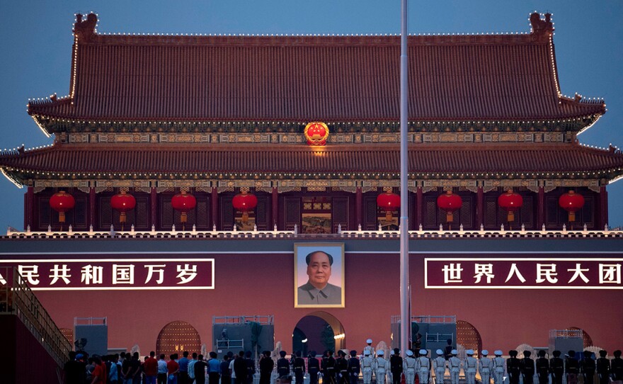 Chinese honor guards stand in formation during the lowering of the national flag in front of Tiananmen Gate in Beijing on Monday, one day before the 70th anniversary of the founding of the People's Republic of China.