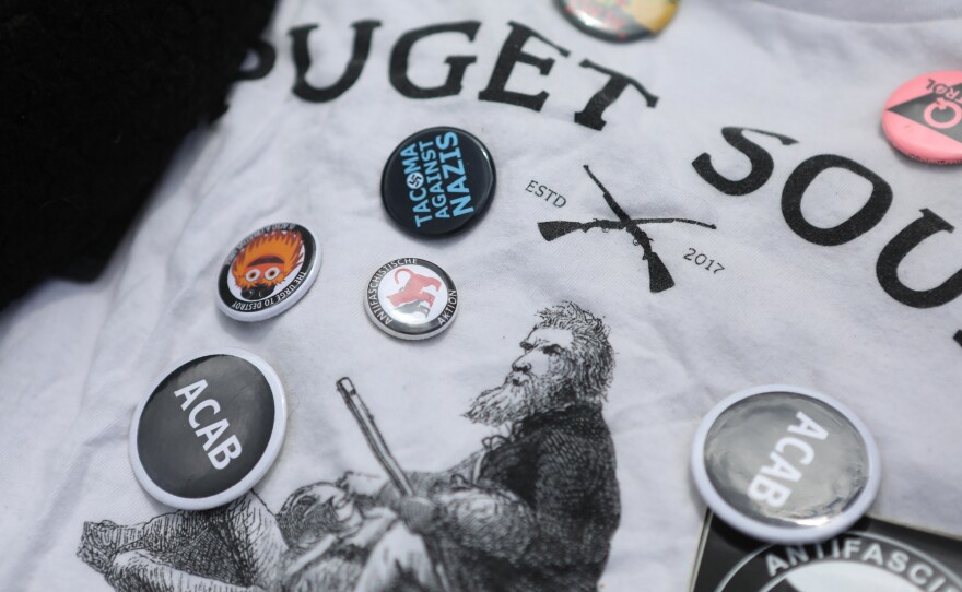 A shirt and pins that belonged to van Spronsen. He stood up to far-right leaders at local rallies, and he was a fixture at demonstrations against U.S. immigration policies, especially family separation. "Kids in cages," he called it.
