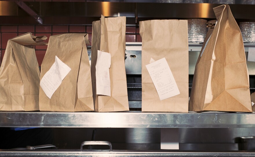 Restaurant takeout bags await customer pick-up in an April 2020 photo.