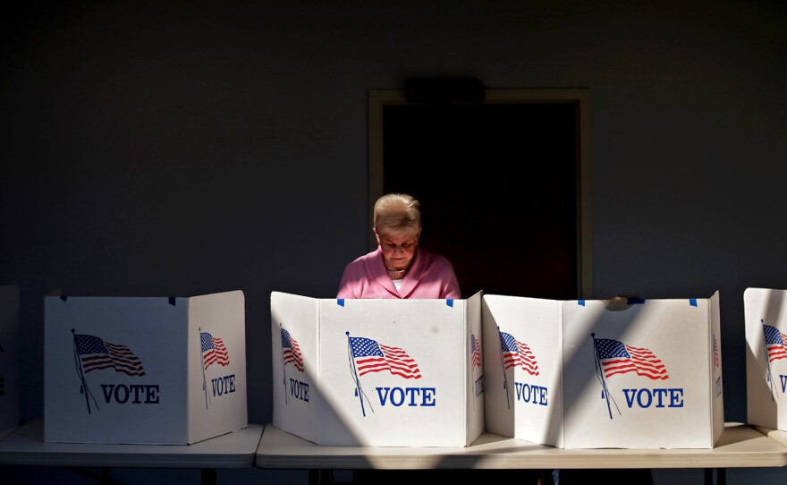 A voter casts her ballot at Fairfax Circle Baptist Church in Fairfax, Va.