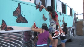 Activists paint the vintage bus they plan to drive across the South to protest deportations.