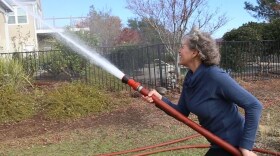 Kathy Houston demonstrates how she saved her Butte County house in the Camp Fire by wetting it down with a high-pressure hose in this undated photo. 