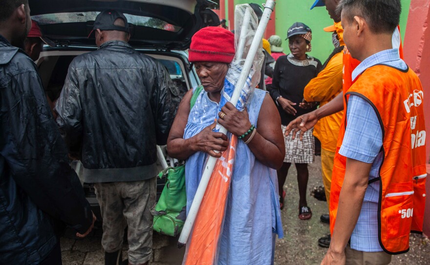 Haitians receive umbrellas as part of humanitarian aid after a 7.2 magnitude earthquake struck Haiti on Aug. 14.
