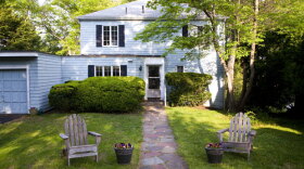 A "before" photo of the "This Old House" Auburndale project. The Auburndale project features a dated home situated on a postcard perfect plot of land along the Charles River of Boston. The stark 1940s suburban home, located in Auburndale, Massachusetts, doesn’t fit in with the charming neighboring properties and is in desperate need of major updating. The crew plans to infuse some character and curb appeal by adding new doors and a gabled roof to the garage, additional windows and a pergola to the front and creating an entirely new sun porch and deck with a waterfront view.