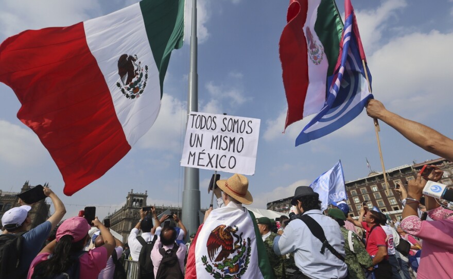 A person holds a sign that reads "we are all the same Mexico" at an opposition rally called to encourage voting ahead of the June 2 presidential elections, in the Zocalo, Mexico City's main square, Sunday, May 19, 2024.