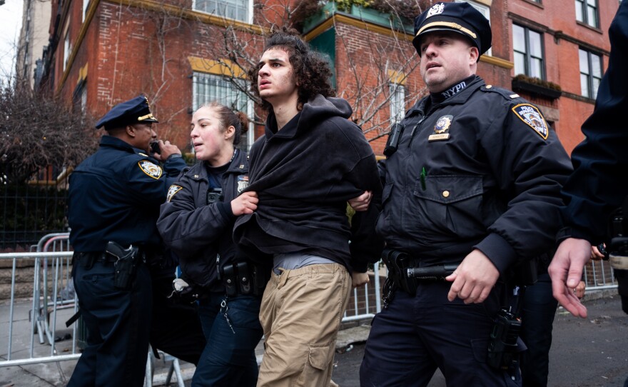 Police detain a man after he attempted to detonate an improvised explosive device during a counterprotest against an anti-Islam protest outside Gracie Mansion.