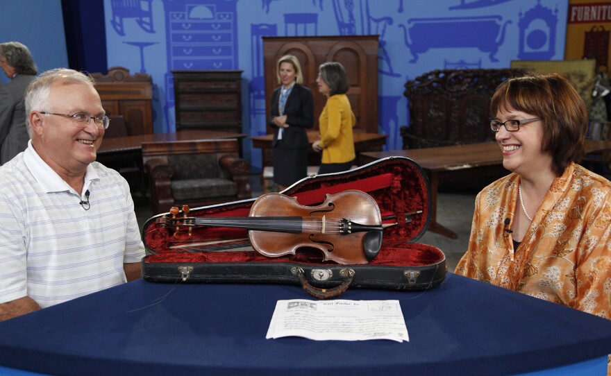 Claire Givens (right) appraises an 1808 Johann Gottlob Herberlein violin, in Madison, Wis. ANTIQUES ROADSHOW “Vintage Madison 2024, Hour 2” premieres Monday, October 28 at 8/7C PM on PBS.