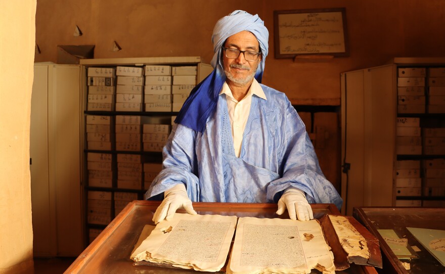 Mohammed Lemine reviewing damaged manuscripts