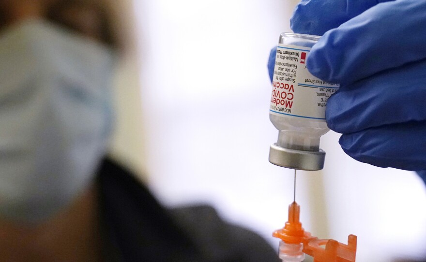 A booster dose of the Moderna COVID-19 vaccine is prepared during a vaccination clinic on Dec. 29, in Lawrence, Mass. The FDA is now shortening the wait time between the second dose and the booster to five months from six months.