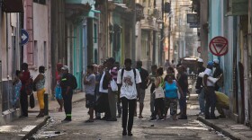 People line up in the street to buy bread in Havana, Cuba, Friday, March 13, 2026.