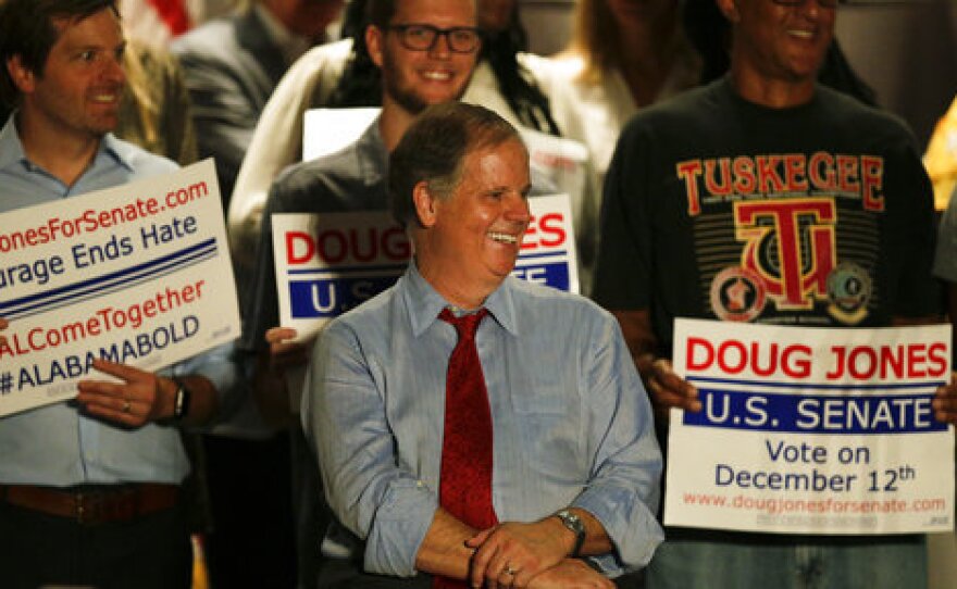 Democrat Doug Jones speaks at a campaign rally earlier this month in Birmingham, Ala. He is campaigning on what he calls "kitchen table" issues, including health care, jobs and education.