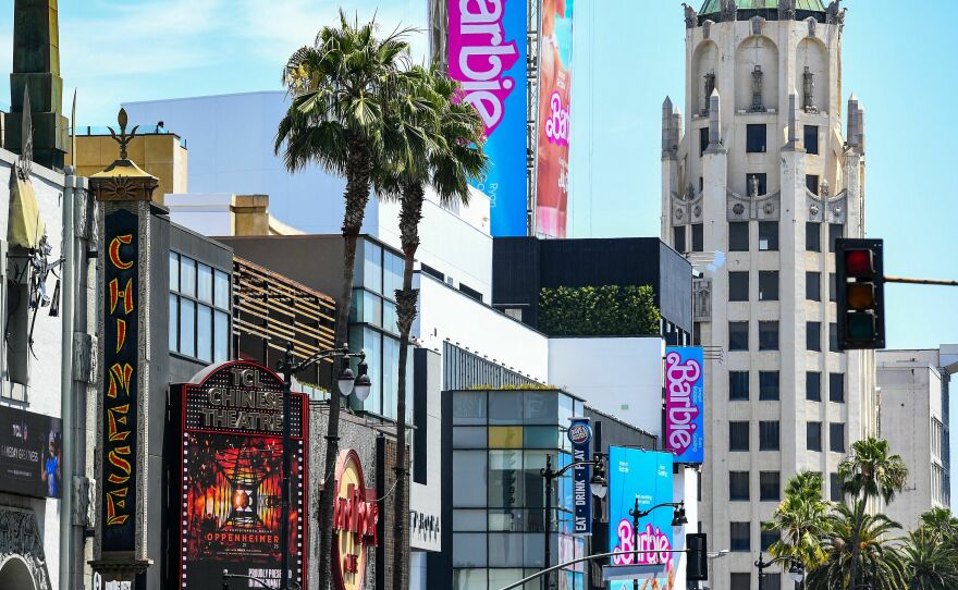 Advertisements for <em>Oppenheimer</em> and <em>Barbie</em> are seen above the Hollywood Walk of Fame on Friday.