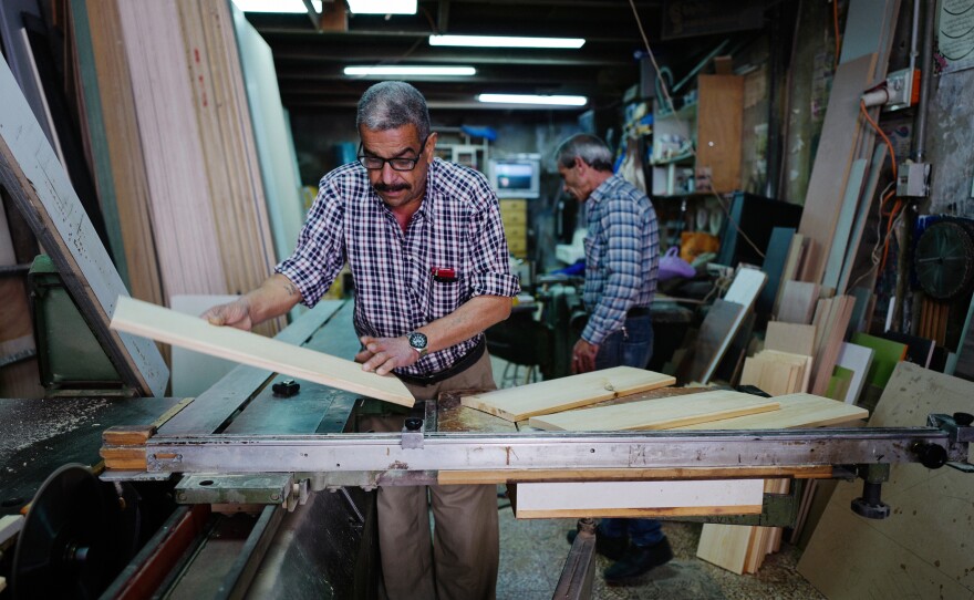 Joudeh Said runs a carpentry business in the West Bank. "No one is paying," he says. "They give me a check, and then the check bounces, and then I have to chase them."