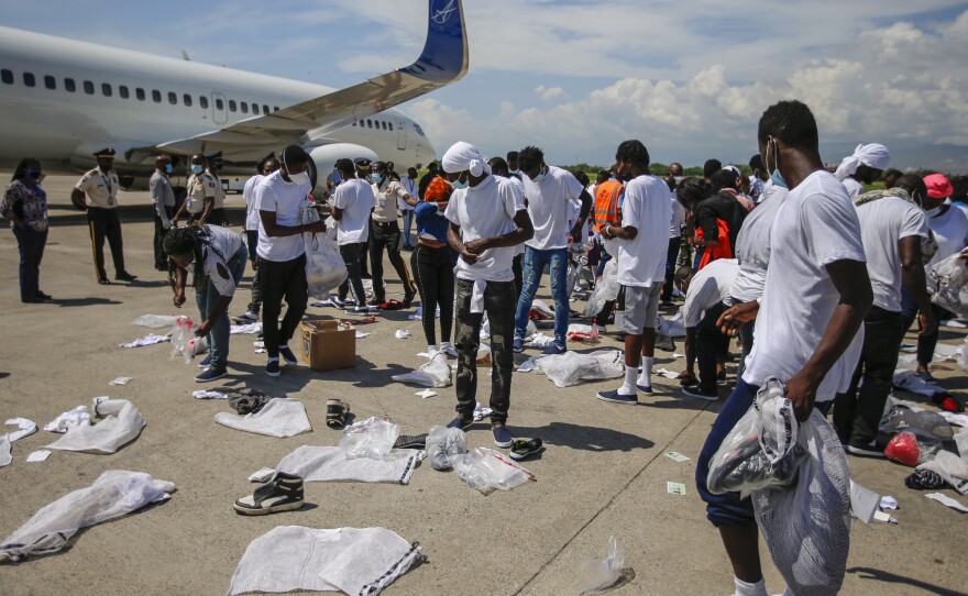 Haitians deported from the U.S. recover their belongings scattered on the tarmac of the Toussaint Louverture airport in Port-au-Prince, Haiti, on Tuesday.