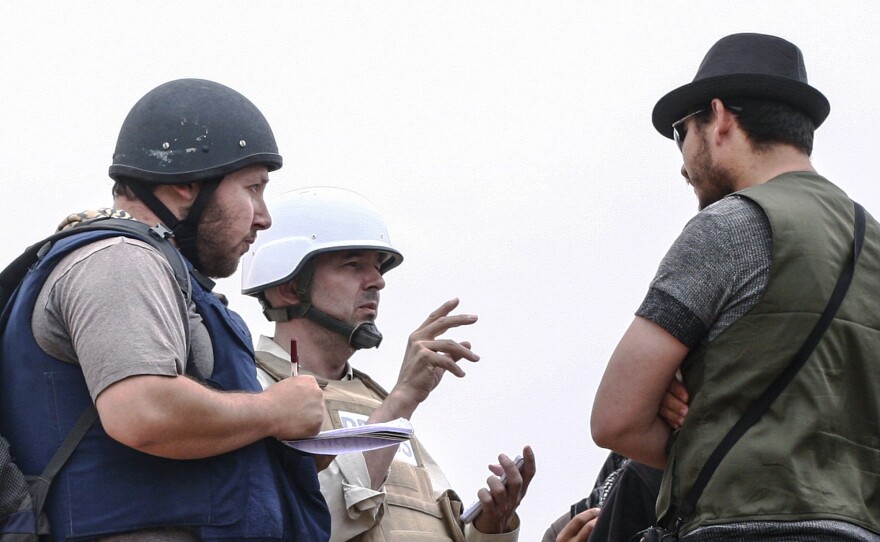 In this handout image made available by the photographer American journalist Steven Sotloff (left) talks to Libyan rebels on the Al Dafniya front line on June 2, 2011 in Misrata, Libya. Sotloff was kidnapped in August 2013 near Aleppo, Syria.