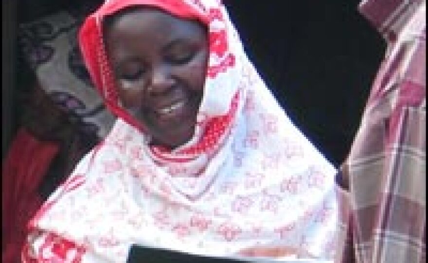 Village savings-and-loan member Hadija Kibwana, left, talks to CARE's Abubakaray Othman Masoud, who facilitated a yearlong training program for the women in the village of Soga.