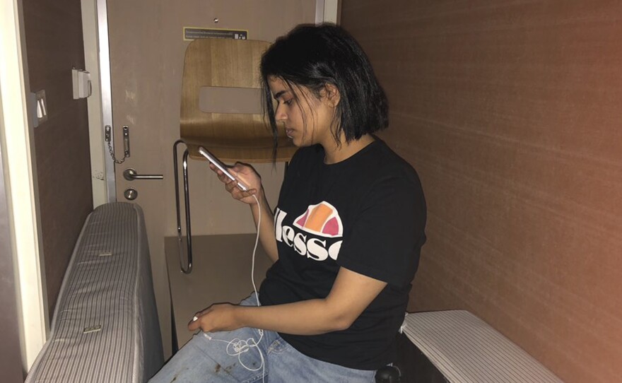 Rahaf Mohammed Alqunun on her mobile phone as she sat barricaded in a hotel room in Thailand's international airport in Bangkok on Monday.
