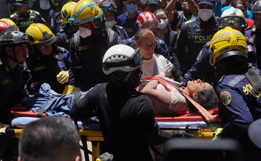 Rescue workers carry Diana Troncoso after pulling her from the rubble the day after an earthquake struck Cali, Colombia, Tuesday, Aug. 11, 2026.