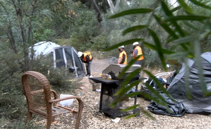 A group of homeless outreach workers with City Net are pictured at a homeless encampment near the 805 South in Chula Vista on November 2021.