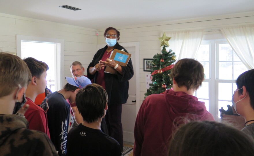 Museum guide Aisha Hosey talks to a group of students.