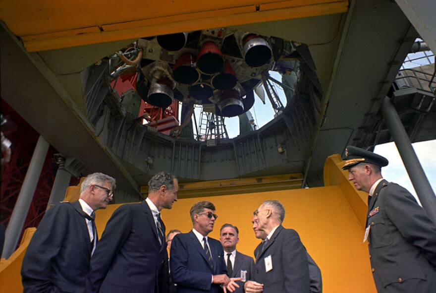President John F. Kennedy (with sunglasses) is briefed by NASA officials at the Saturn rocket at Pad B, Complex 37, Cape Canaveral, Fla. Nov. 16, 1963.