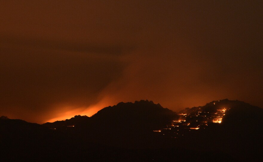 Fire lights the sky near Idyllwild, Calif., early Thursday. Flames have spread close to Palm Springs.