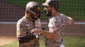 San Diego Padres' Eric Hosmer, right, reacts with teammate Fernando Tatis Jr after both scored off a two-RBI double by Tommy Pham during the eighth inning of a baseball game against the Los Angeles Dodgers, Sunday, April 18, 2021, in San Diego. 