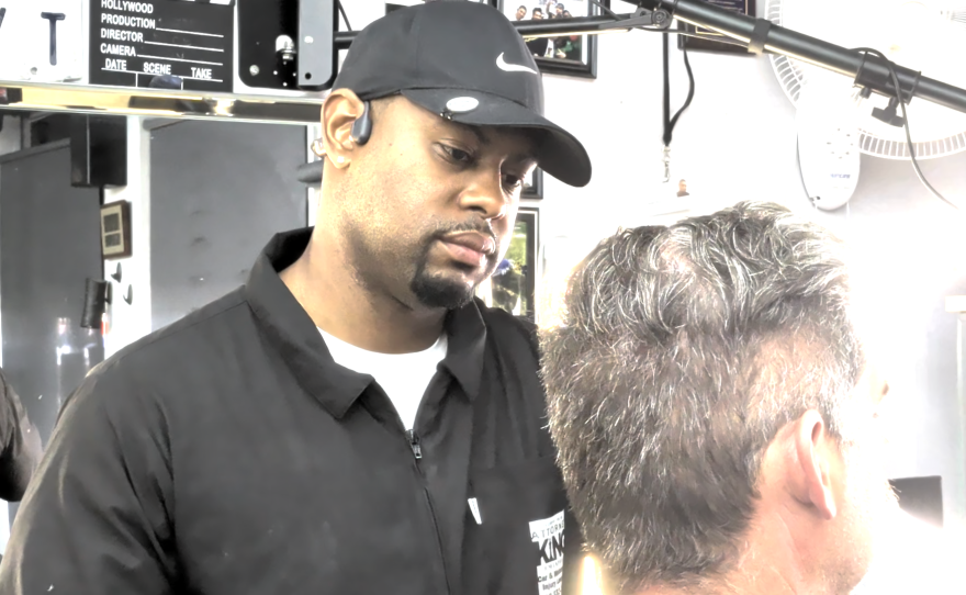 Barber Tony Ganaway cuts a client's hair at the Cutt'n Edge Barber Shop.